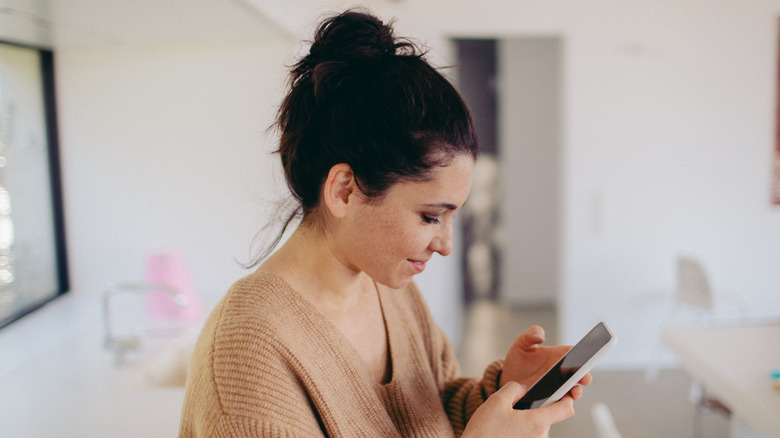 Woman with bun on her phone