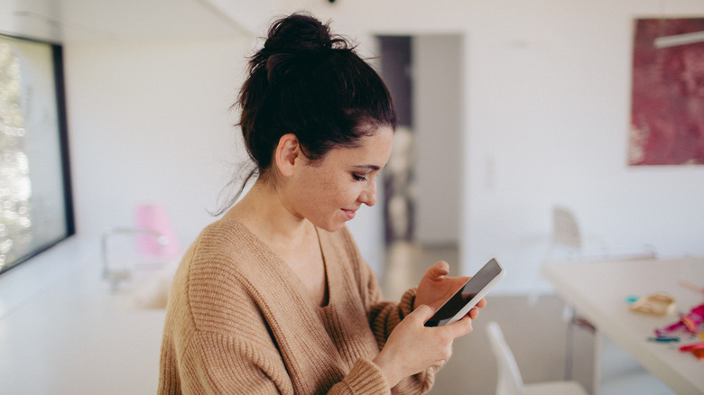 Woman with bun on her phone