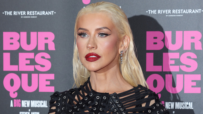 Christina Aguilera with dark red lips on a red carpet in 2026