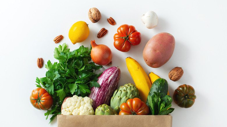 fruits and vegetables spilling out of paper bag