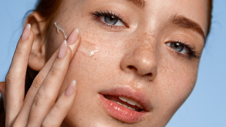 Woman putting on sunscreen