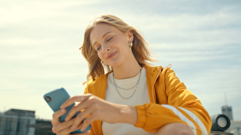 Smiling woman using smartphone