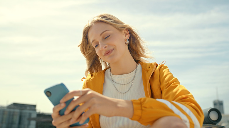 Smiling woman using smartphone