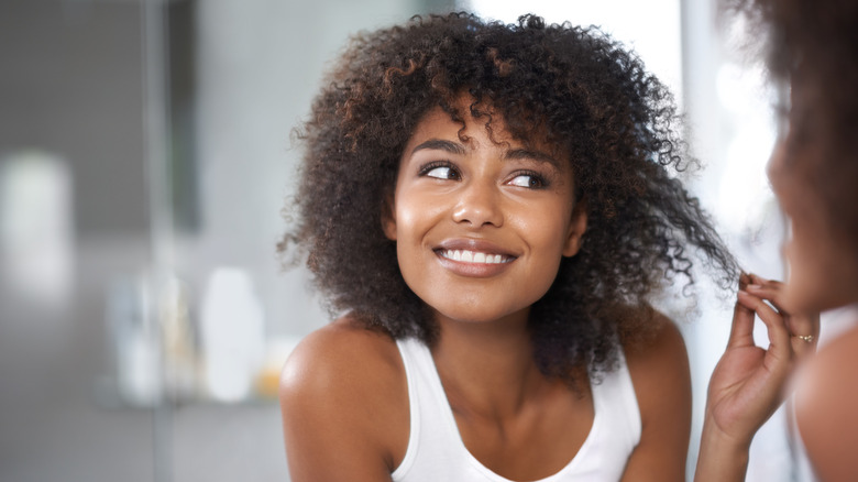 smiling woman pulling her curls