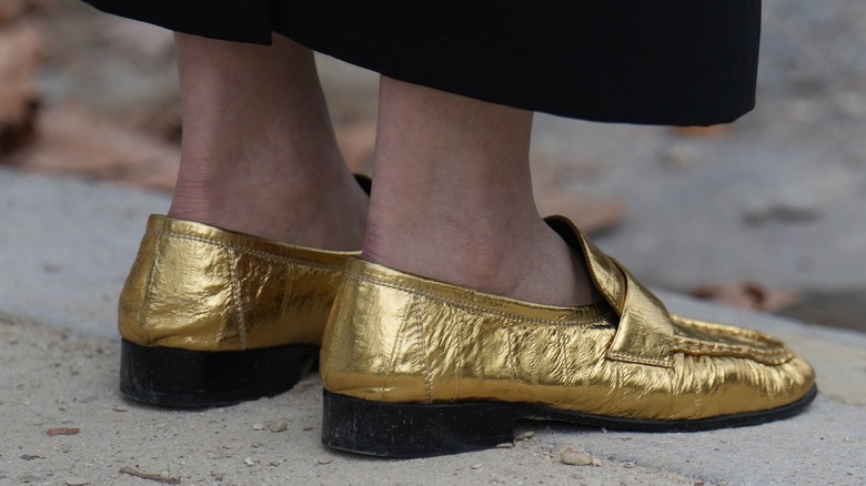 woman wearing gold loafers