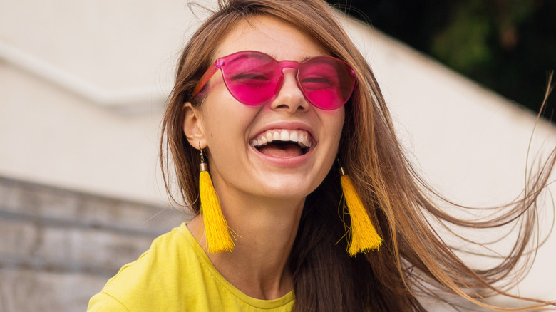 Laughing woman wearing pink sunglasses