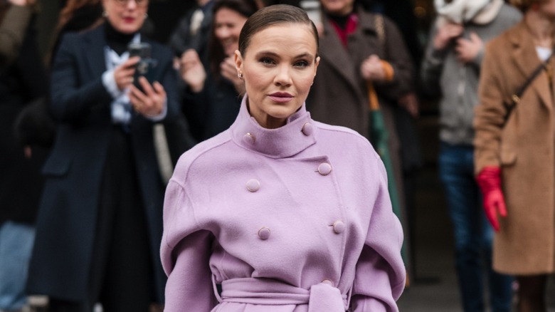 A guest in a lavender purple pea coat during Paris Fashion Week in March 2024