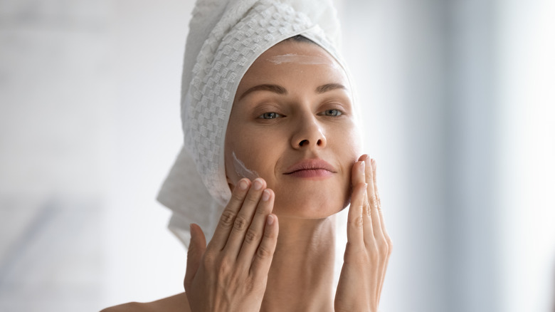 woman applying cream to skin