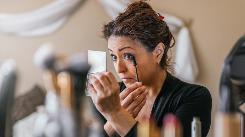 A woman applying eye liner