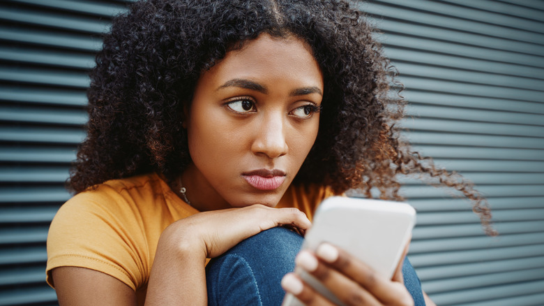 Woman looking sad at phone 