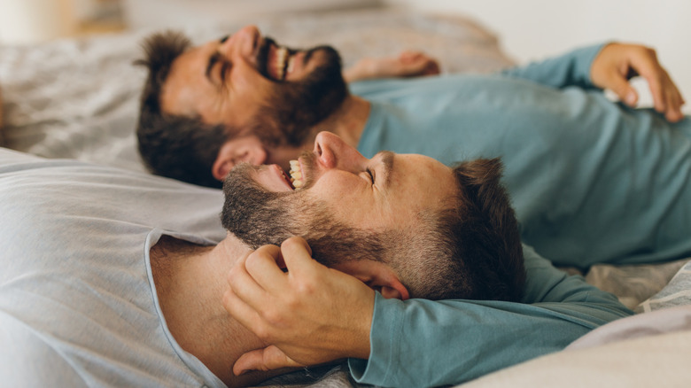 Couple laugh on bed