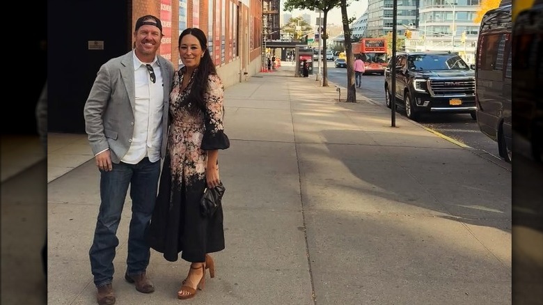 Joanna Gaines wearing a floral dress with Chip Gaines