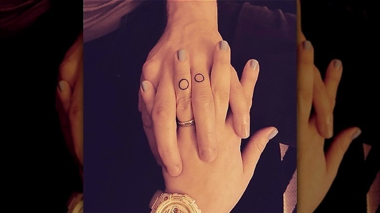 couple with circle wedding band tattoos