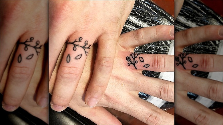 couple wearing cherry blossom wedding ring tattoos