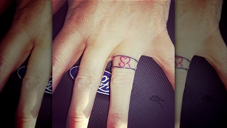 person with initials wedding ring tattoo