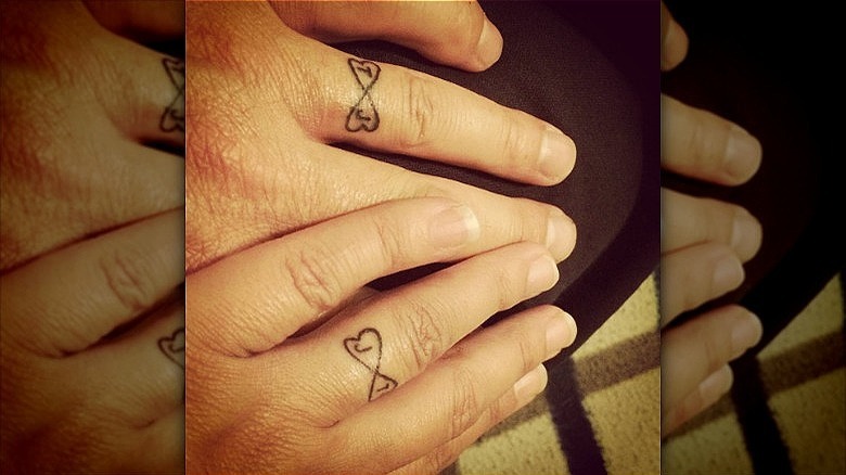 couple wearing wedding ring tattoos