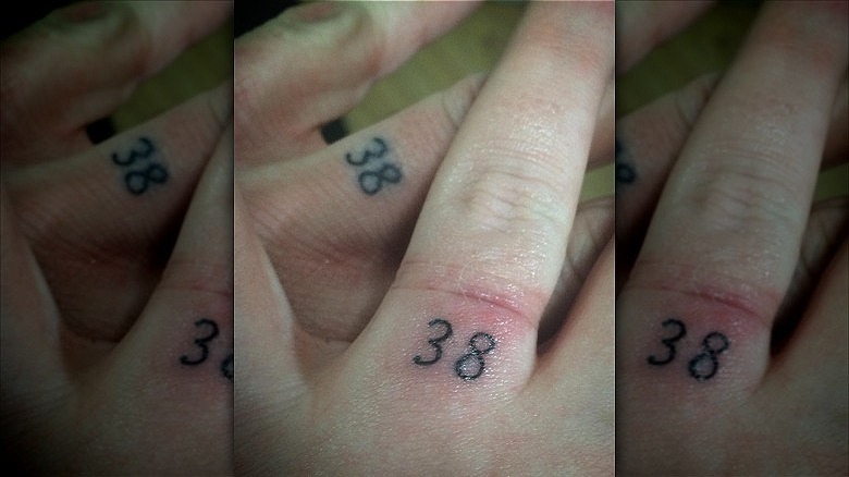 couple with number wedding ring tattoos