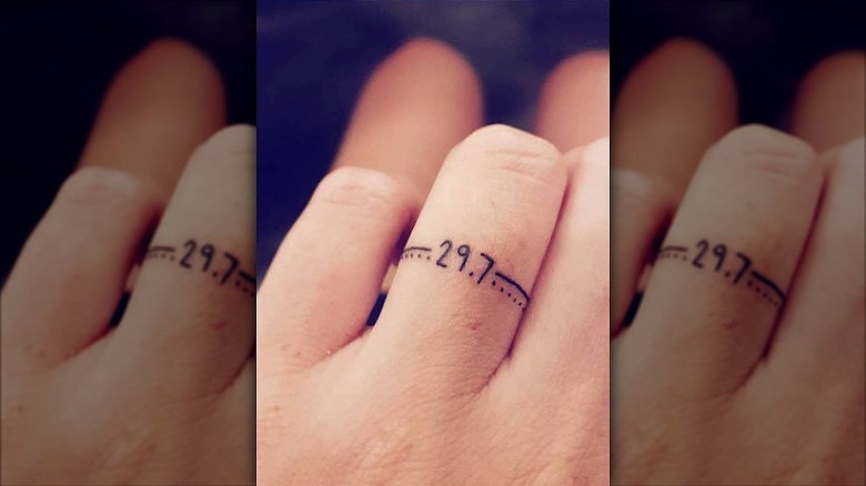 woman with wedding date ring finger tattoo