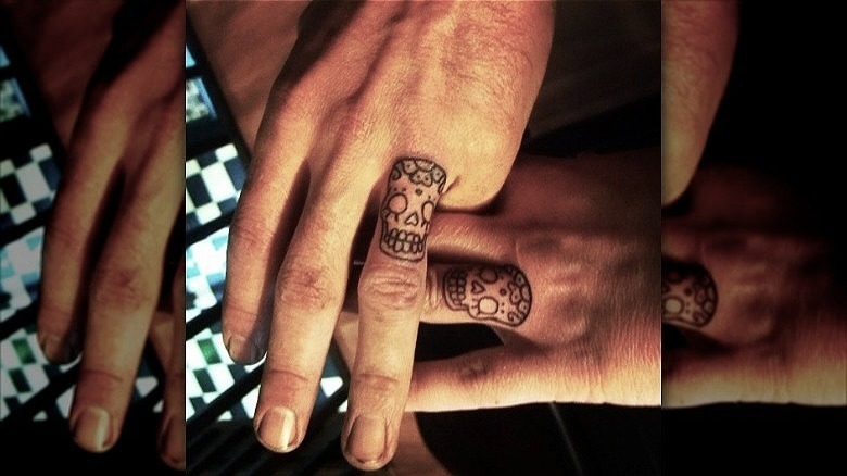 couple with skull ring finger tattoos