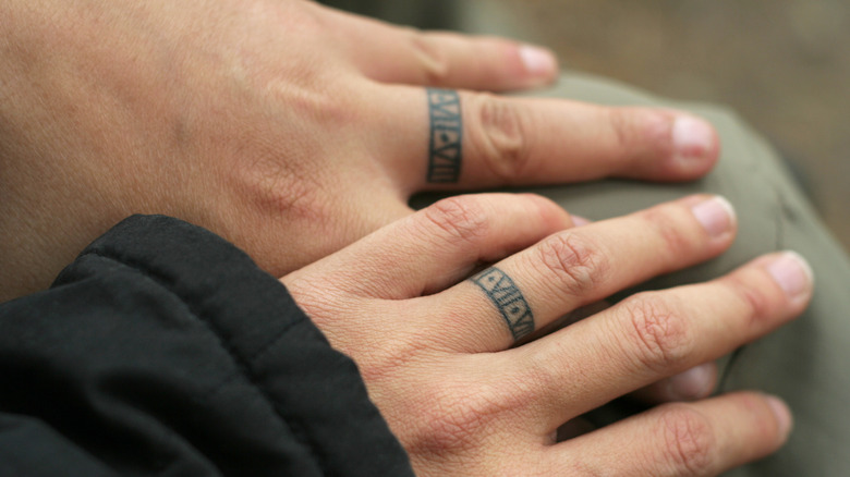 couple wearing wedding ring tattoos