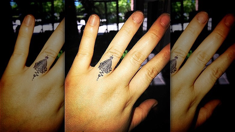 woman with intricate ring finger tattoo