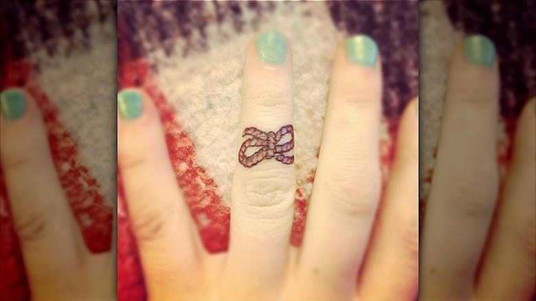woman with knot tattoo on ring finger