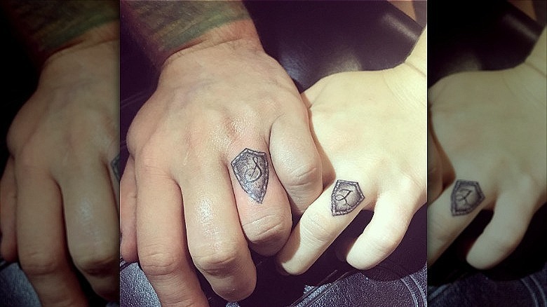 couple with shield wedding ring tattoos