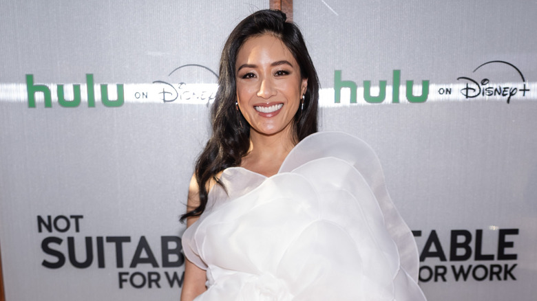 Constance Wu wearing a white dress and makeup