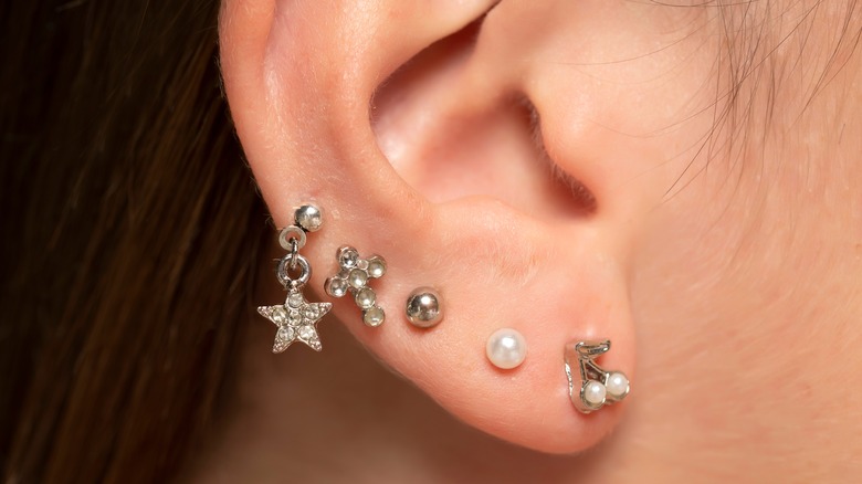 Person wearing constellation piercings on their ear