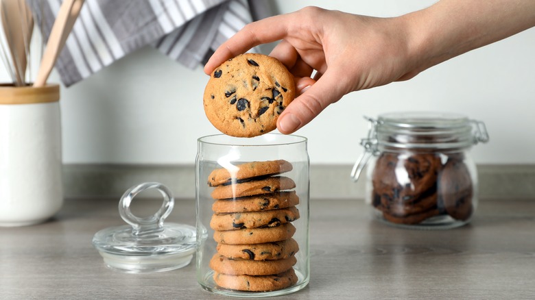 person taking cookie from jar