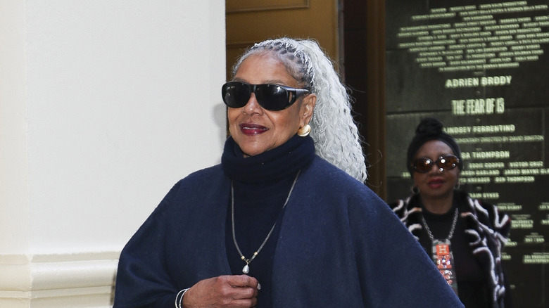Phylicia Rashad wearing her hair in a braided ponytail and black sunglasses