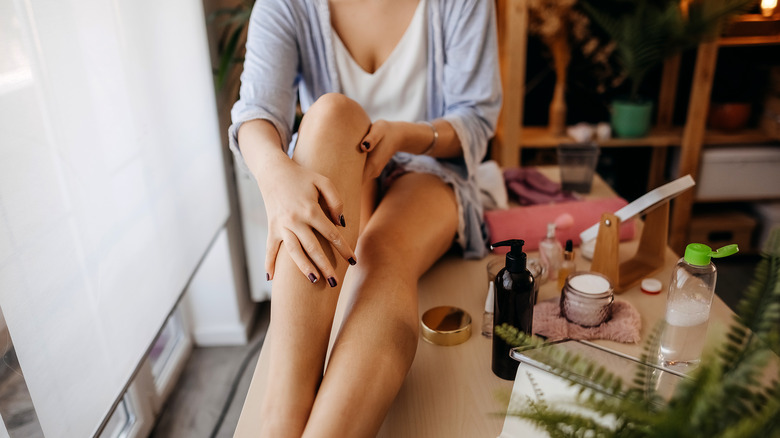 Woman rubbing legs after shaving