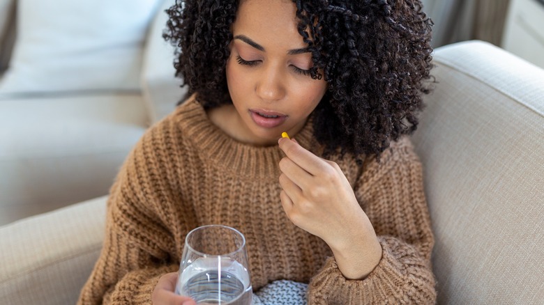 woman working in pharmacy holding birth control pills