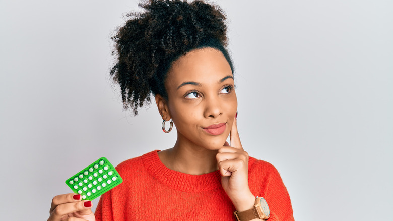 woman holding birth control pills