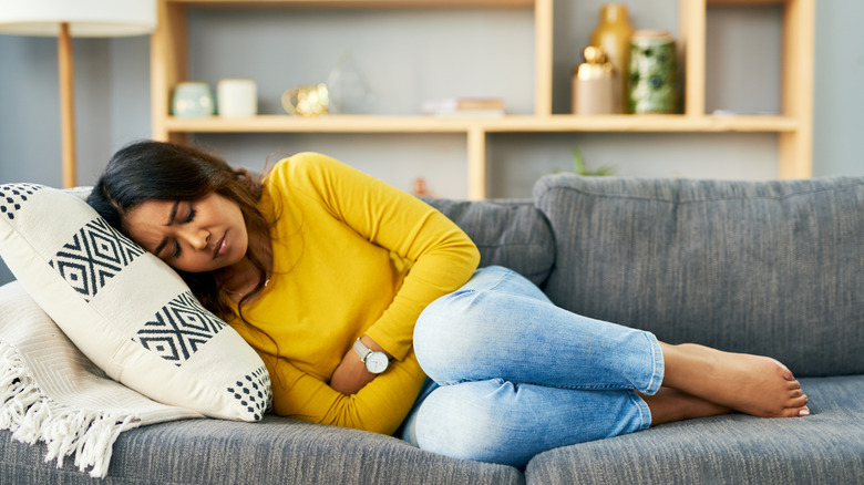 woman on couch with cramps