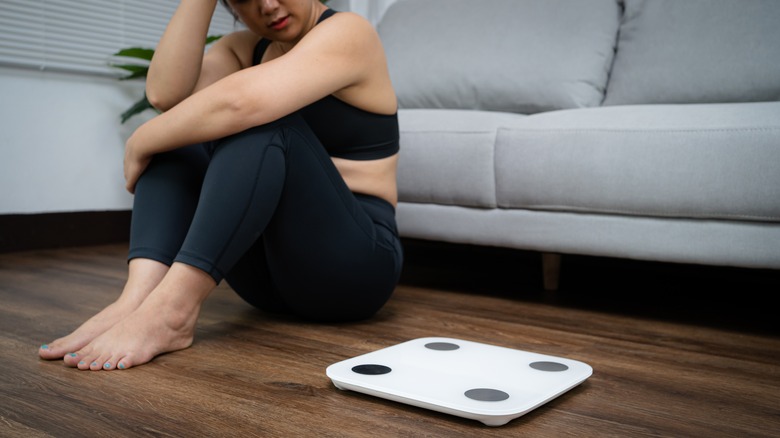 Woman sitting by her scale