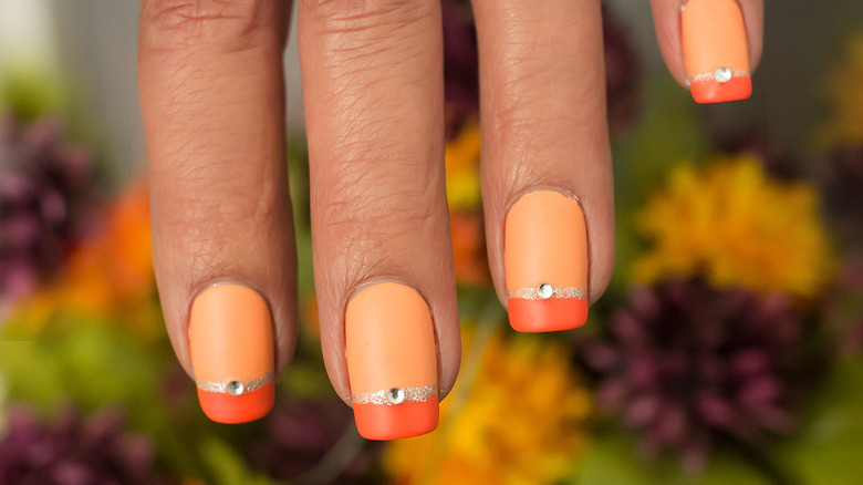woman with orange creamsicle nails