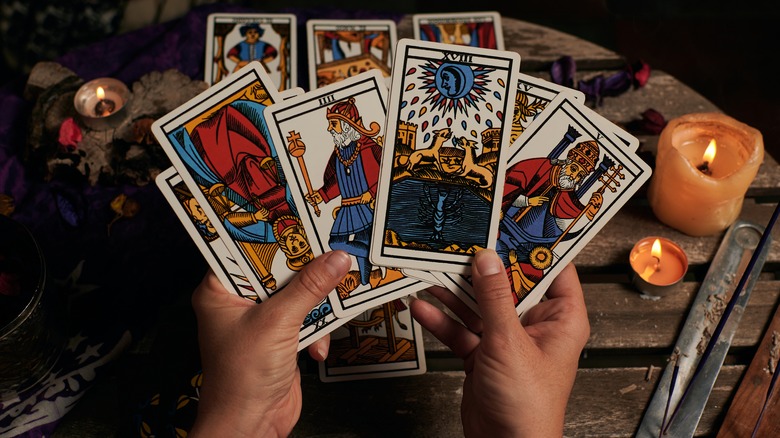 hands holding out tarot cards