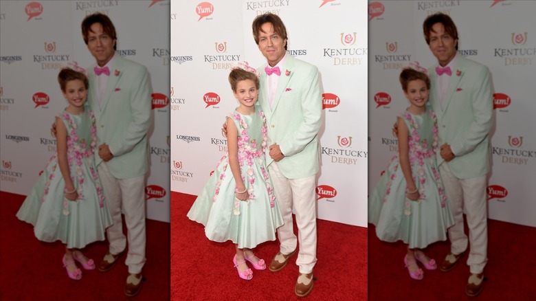 Dannielynn Birkhead smiles next to Larry Birkhead wearing a mint green floral dress