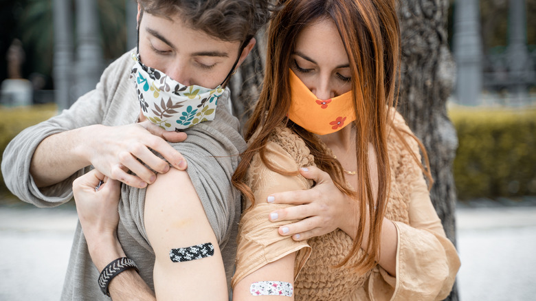 A couple showing off vaccines