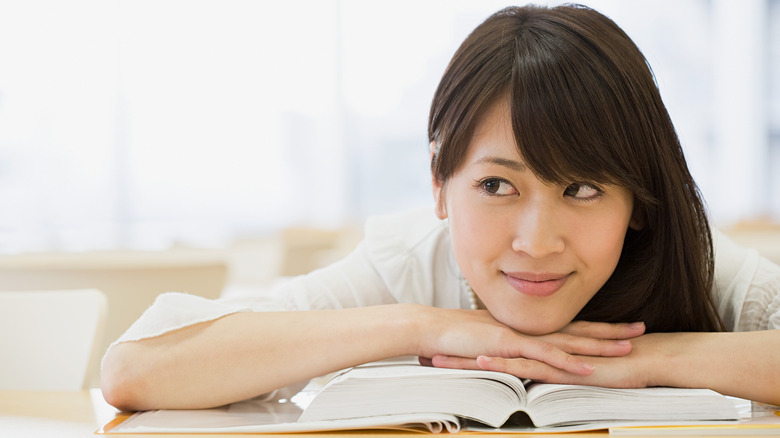 woman smiling up from book