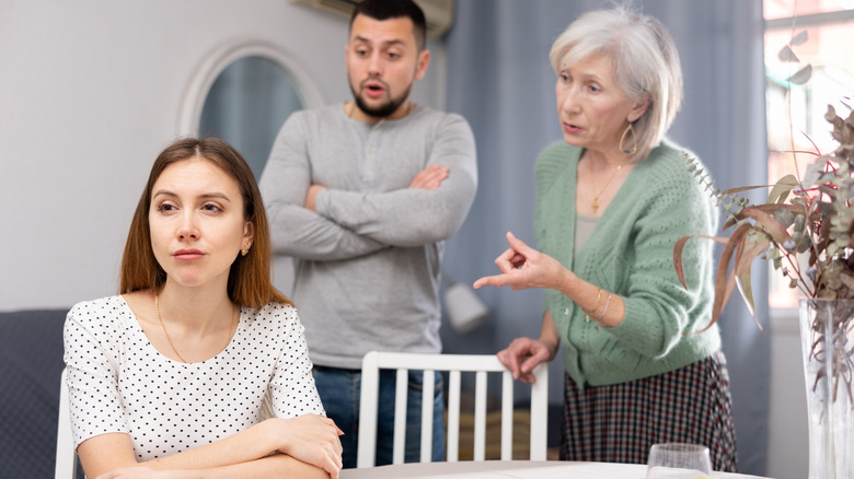 In-laws talking to annoyed woman