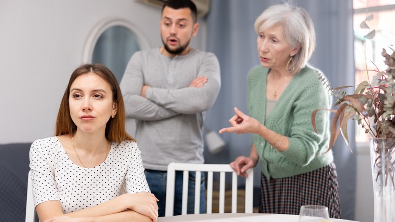 In-laws talking to annoyed woman
