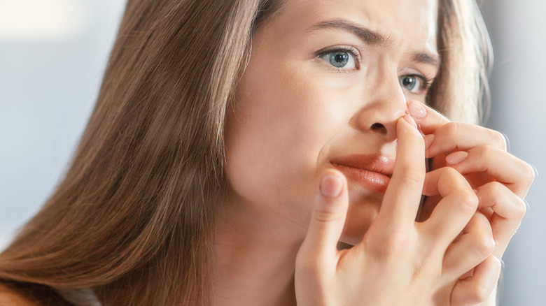woman looking at nose acne