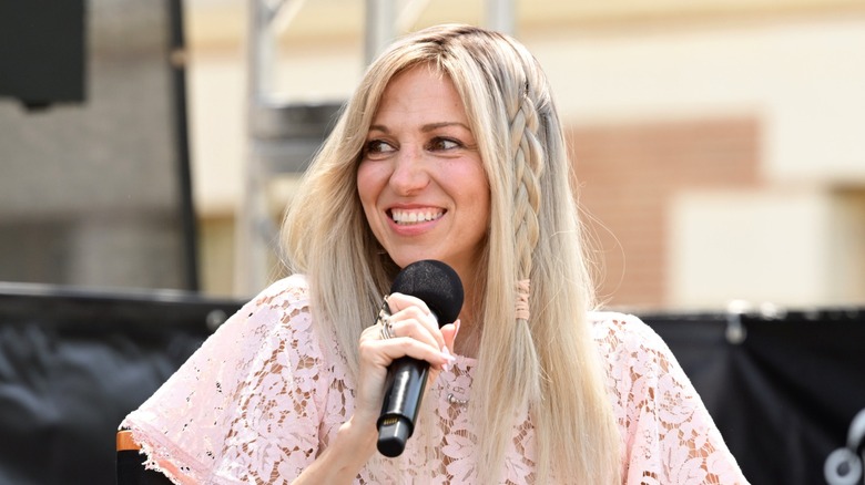 Debbie Gibson wore her long blond hair down with a loose braid on the side and a pale pink lacy shirt while speaking at the 2026 Los Angeles Times Festival of Books in Los Angeles.