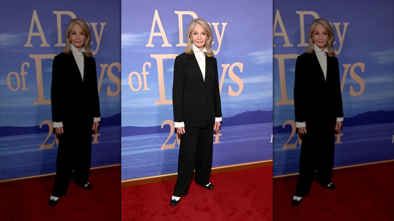 Deidre Hall smiles wearing a pinstripe suit