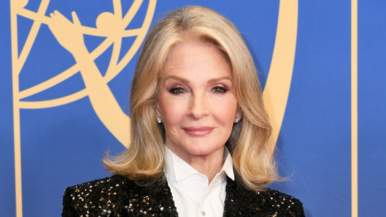 Deidre Hall smiles wearing a white shirt and a black glitter blazer