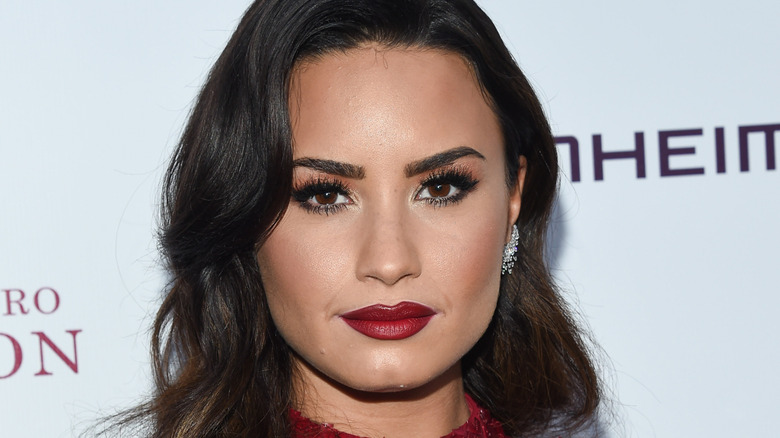 Demi Lovato posing on the red carpet with long, wavy hair