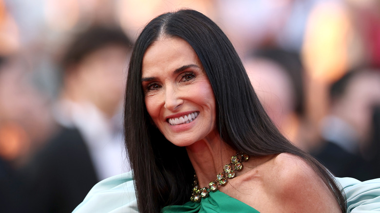 Demi Moore at a red carpet event wearing a green gown with billowy sleeves.