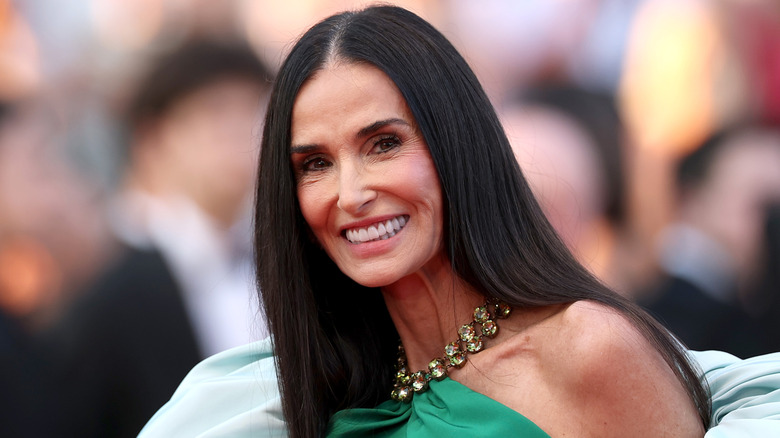 Demi Moore posing in a green gown with a jeweled neckline in 2026.